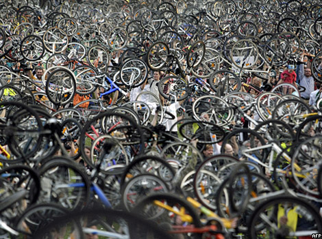 Cyclists holding their bikes in the air