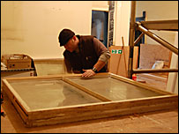 A carpenter working on one of the windows