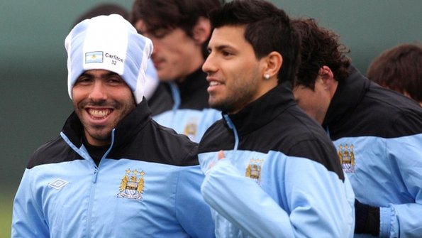 Carlos Tevez in training with team-mate Sergio Aguero (right)