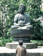 Japanese woman standing in front of a statue of Buddha