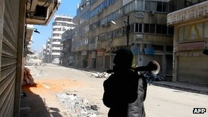 A man carries a Rocket Propelled Grenade (RPG) in the al-Hamidiya neighbourhood of Homs