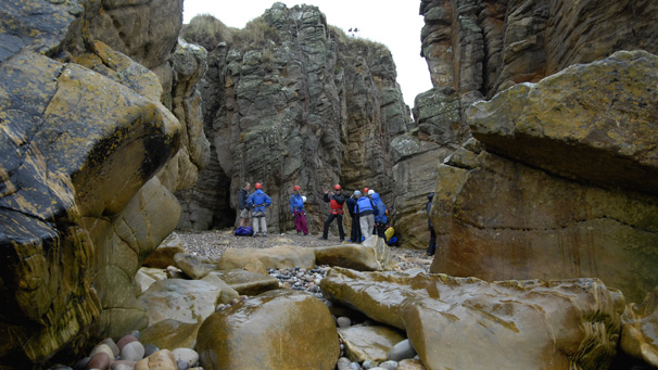 View of a rocky beach and cliffs as participants prepare for their climb