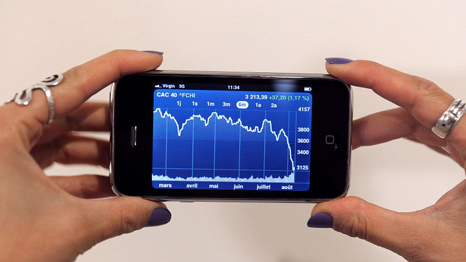 A woman looking at a financial application on her phone (AFP)