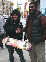 Mohammed paints a local's skateboard