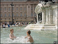 Crianças brincam em fonte na frente do Buckingham Palace