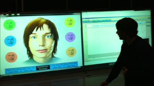 Person walks past computer screen at Abertay University