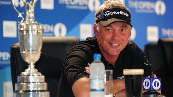 Darren Clarke looks at the Claret Jug as he celebrates with a pint of Guinness at his media conference 