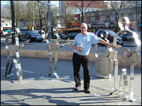 BBC Radio Manchester reporter Ian Cheeseman poses with statues of the Beatles in Hamburg