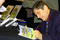 Harri Parri yn arwyddo copi o'i lyfr