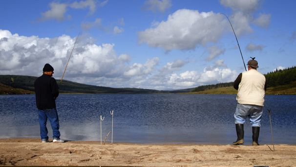 Two men fishing on the sandy beach of Loch Grannoch