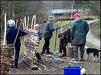 Volunteers making hazel hurdles