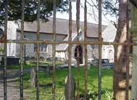 Edrych drwy'r giatiau tuag at yr eglwys