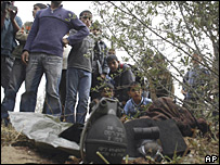 İsrail saldırısından arta kalan mühimmatı inceleyen Filistinliler.