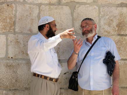 Dr Musharraf Hussain and Rabbi Dr Alan Unterman standing in front of the stone walls of the church