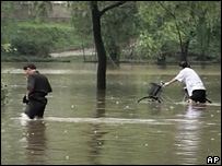 Two people wading through floods in North Korea