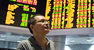 An asian trader glances at the financial information screens