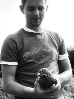 Chris Armstrong on his pigeon farm with one of his homing pigeons. © Chris Armstrong.