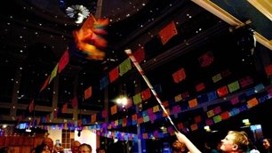 The wedding guests try to poke the pinata