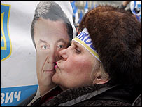 Bir kadın Yanukoviç posterini öperken