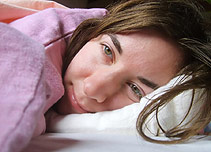 A girl lying awake in her bed