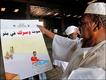 Inspecting a voting poster in Khartoum