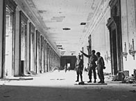 Victorious Allied soldiers inspect the ruins of the Reich Chancellery. The door to Hitler's office is to the right 