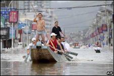 People row a dragon boat to commute through a flooded area in Cangnan county in east China