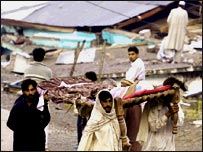 Belakot'ta enkaz altından çıkarılan ceseti taşıyanlar