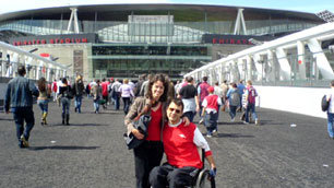 Tim and his wife pose for a photo outside the imposing Emirates Stadium