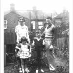 I am standing in front of my grandparent's shelter in Haverhill Rd Balham 1940 with my parents and my brother. We had a narrow escape in the September that the blitz started when a land mine came down and exploded in the road opposite.