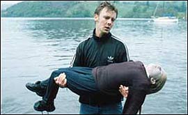 Danny carries the girl's body from the lake.