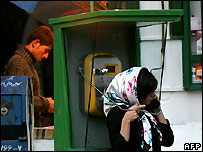 دختری در حال استفاده از تلفن عمومی در تهران