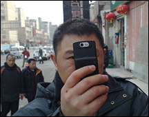 Chinese man takes a photo using his mobile phone