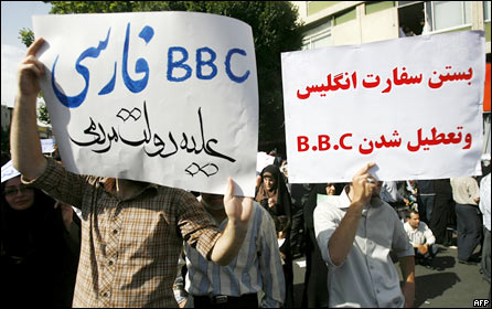 Pro-Ahmadinejad protestors in Iran hold up placards stating (l-r) "BBC Persian TV is against the government of the people" and "Close down the British Embassy and block the BBC"