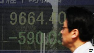 A man watches a stock price board on a street Monday 14 March 2011 in Tokyo