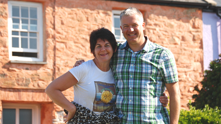 Derek and Gwenno outside a colourful house in Trefin.