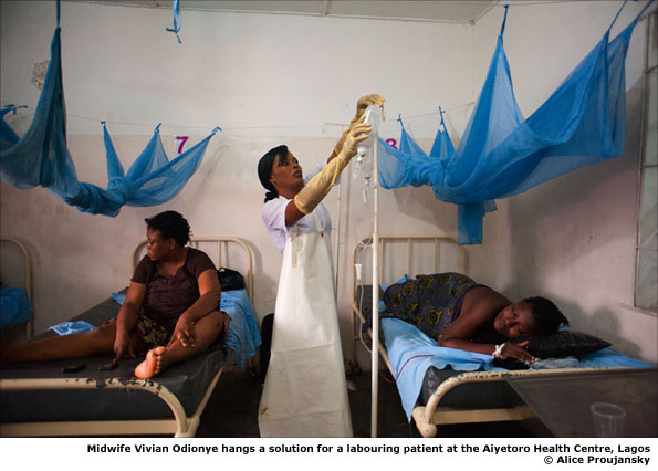 Midwife Vivian Odionye hangs a solution for a labouring patient at the Aiyetoro Health Centre, Lagos © Alice Proujansky