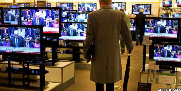 A man watching the chancellor deliver his speech on TV
