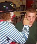 "A camper enjoying getting his face painted by the clown. This was a major treat for the campers and they endorsed it with so much enthuiasm."