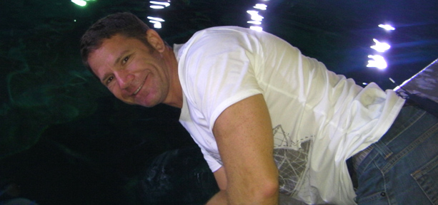 Steve Backshall leaning over a shark tank