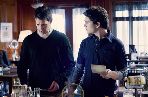 Kyle with a letter in his hand, looking at Adam Baylin