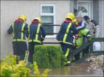 Firefighters rescue someone from mobile home
