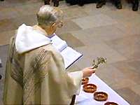 Priest blessing a row of oil dishes