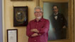 Rolf Harris standing in front of paintings by his grandfather, artist George Frederick Harris