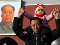 Çin'in kurucusu Mao'nun posteri önünde bir baba ve çocuğu