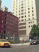 The fenced-off burial site next to two modern buildings
