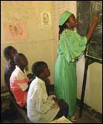 Zambian teacher writing on a blackboard