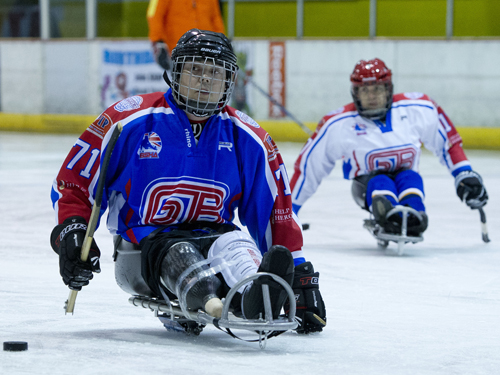 GB sledge hockey players preparing to hit the puck
