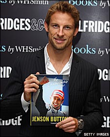 Jenson Button poses with a copy of his diary of his championship year