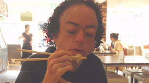 Liz Carr in Japan, trying out eating with chopsticks